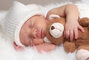 bebé durmiendo abrazando un osos de peluche