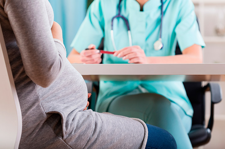 Chica embarazada en consulta con un profesional de la salud