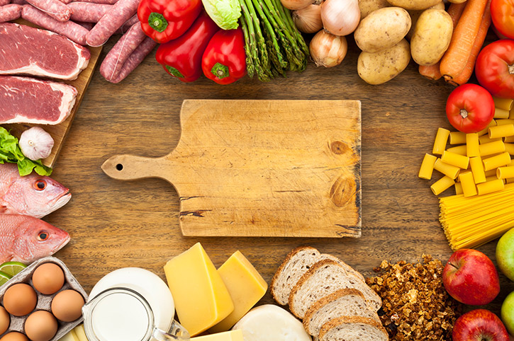 Tabla para picar alimentos con verduras, quesos, pescado y carnes donde se encuentra la vitamina b12 para bebes