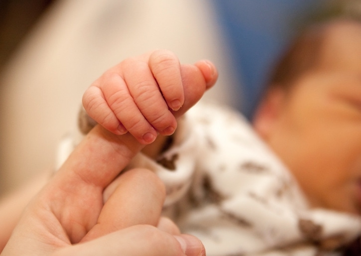 bebé sosteniendo el dedo de su mamá