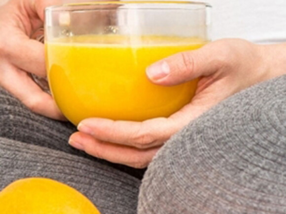 Mujer con jugo de naranja con vitaminas para embarazarse