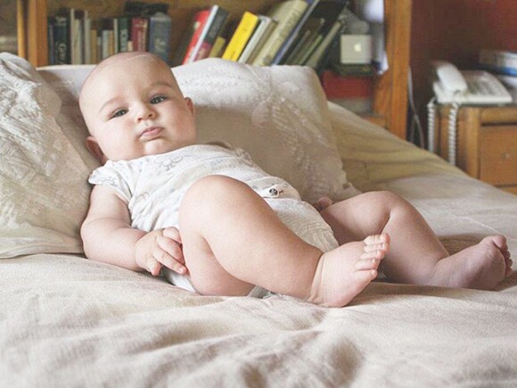 Bebé con problemas digestivos recostado en la cama