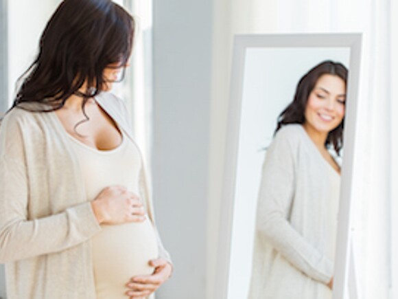 Mujer embarazada frente al espejo