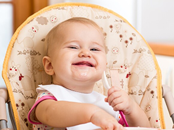 bebe sonriendo y comiendo alimentos para bebe de 9 meses
