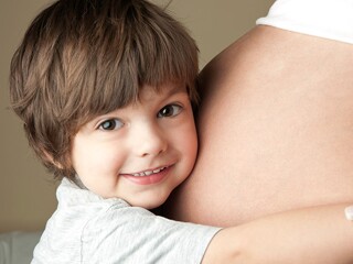niño-pequeño-abrazando-su-madre-embarazada 
