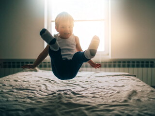 niño saltando sobre la cama