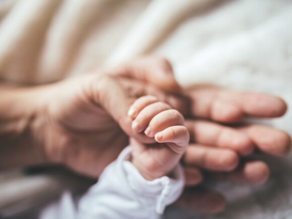 Manos de bebe recien nacido con padres