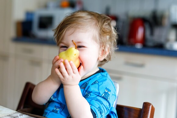 Niño comiendo pera