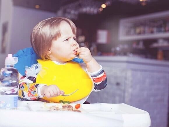 Bebé comiendo alimentos sólidos usando sus manos